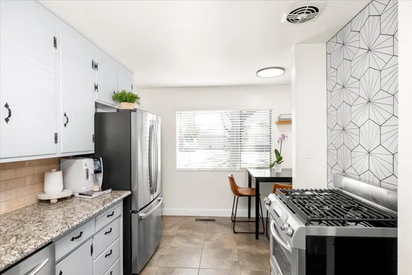 a kitchen with granite countertop white cabinets white appliances and sink
