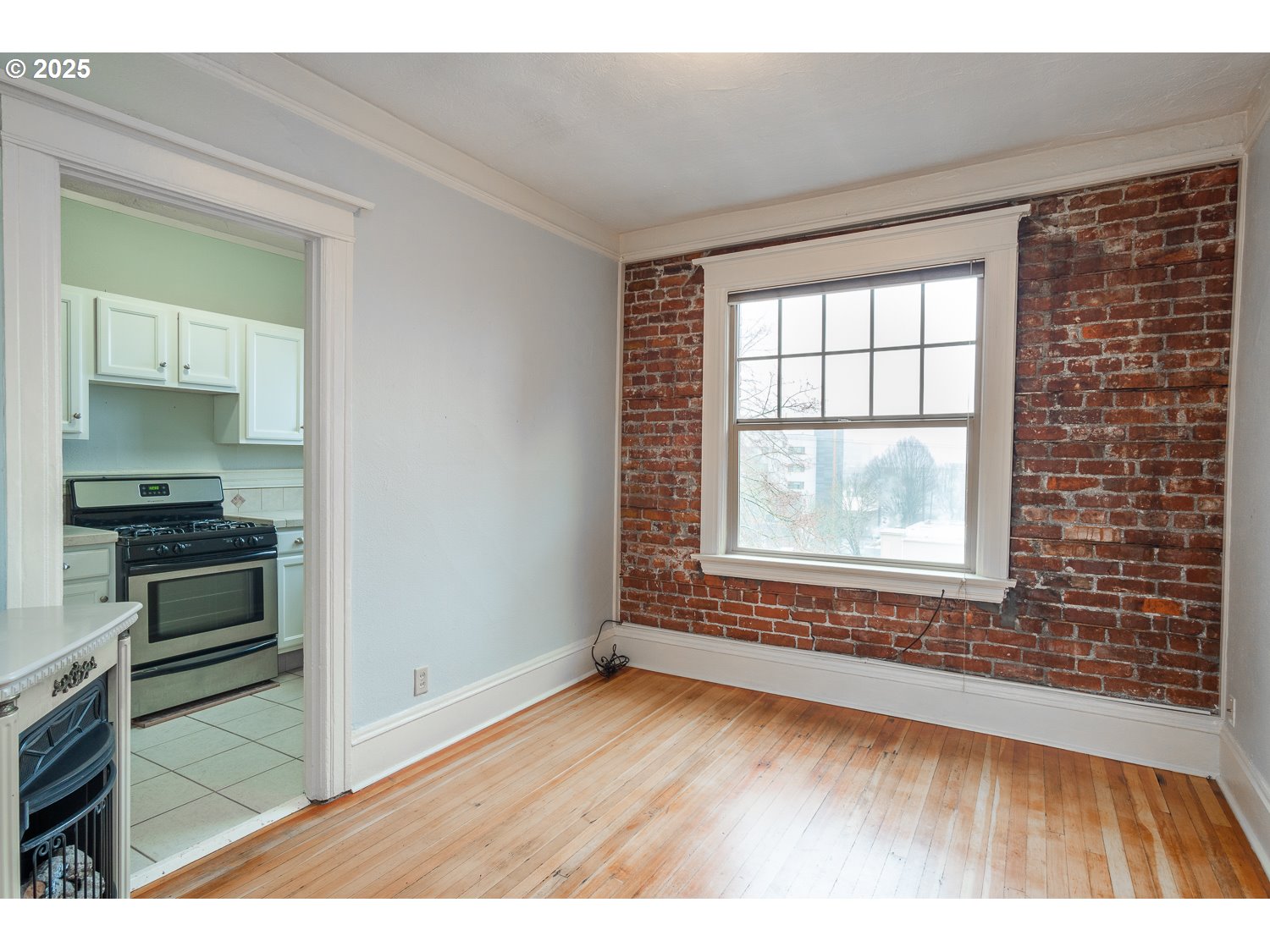 2109 Northwest Irving Street, Unit 407 Portland, OR 97210 - Photo 11 of 17 a view of an empty room with a window and wooden floor