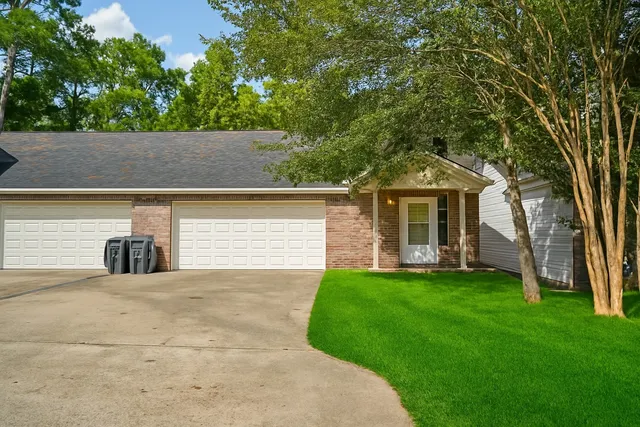 a view of a house with a yard and tree