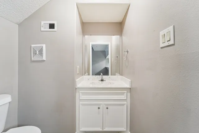 a bathroom with a sink toilet and mirror