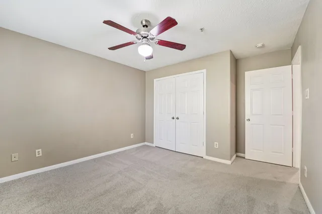an empty room with a ceiling fan and a window