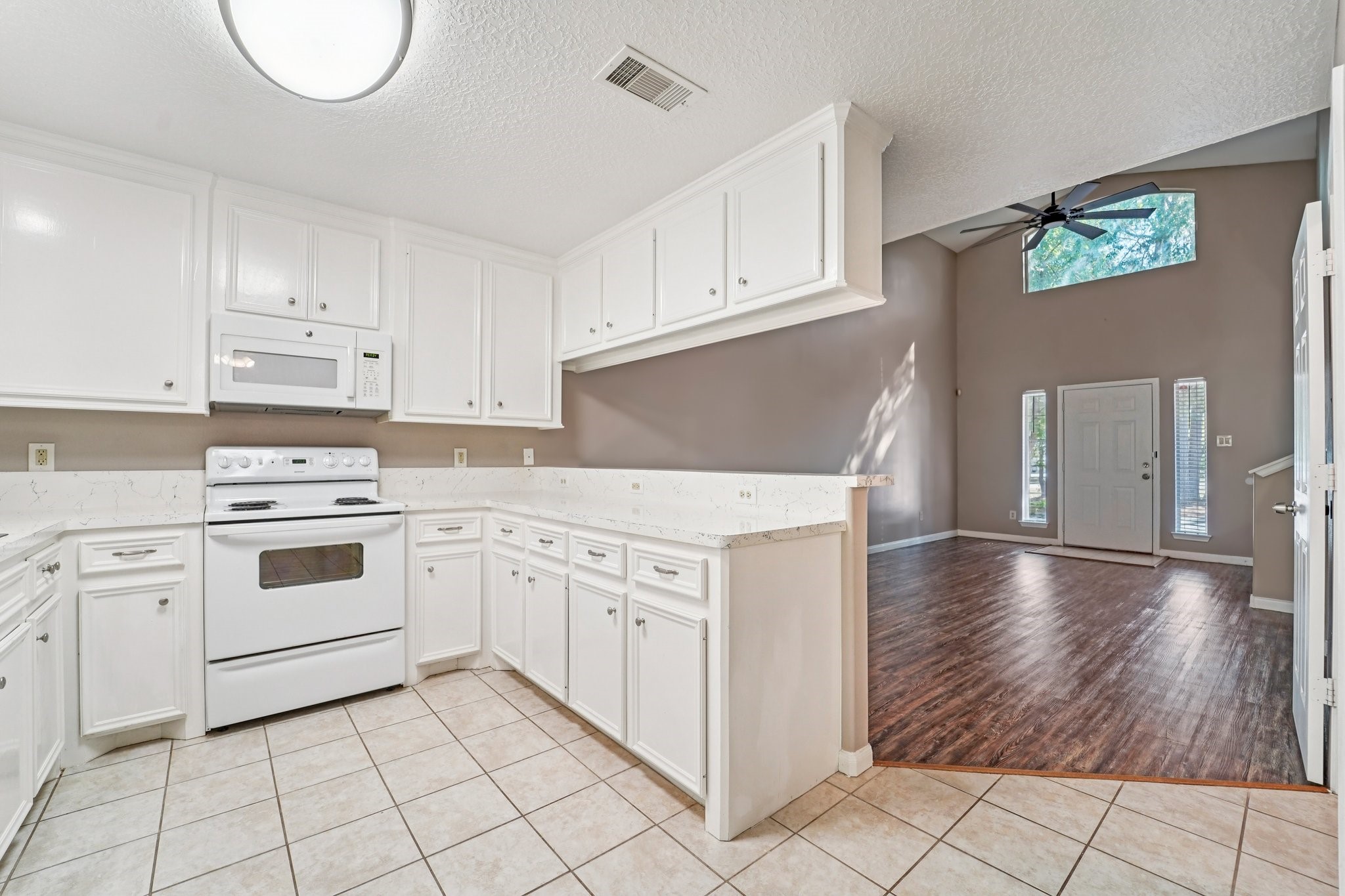 100 Westpark Drive, Unit 5 Conroe, TX 77304 - Photo 5 of 23 a kitchen with granite countertop white cabinets and white appliances