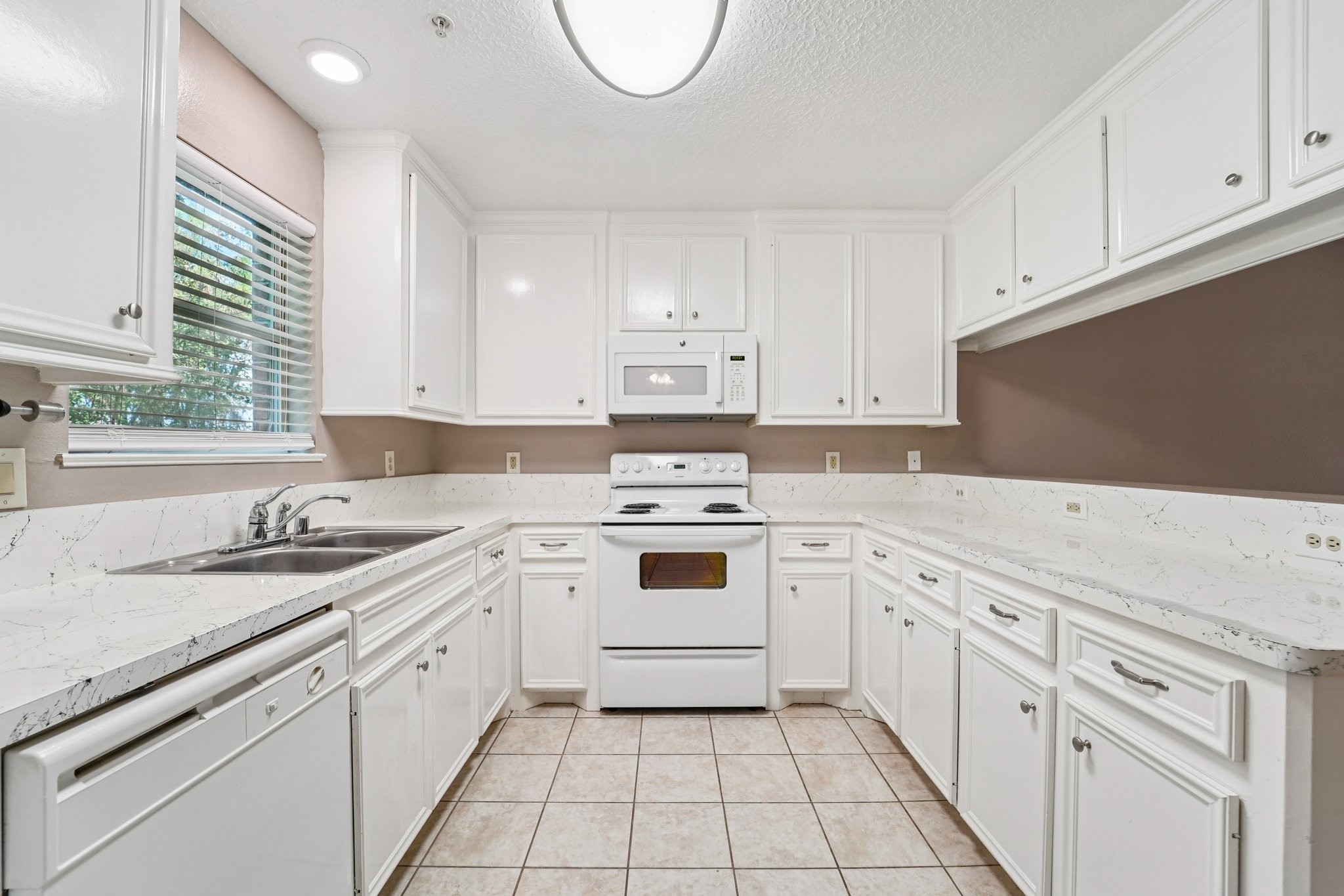 100 Westpark Drive, Unit 5 Conroe, TX 77304 - Photo 6 of 23 a kitchen with cabinets appliances a sink and a counter top