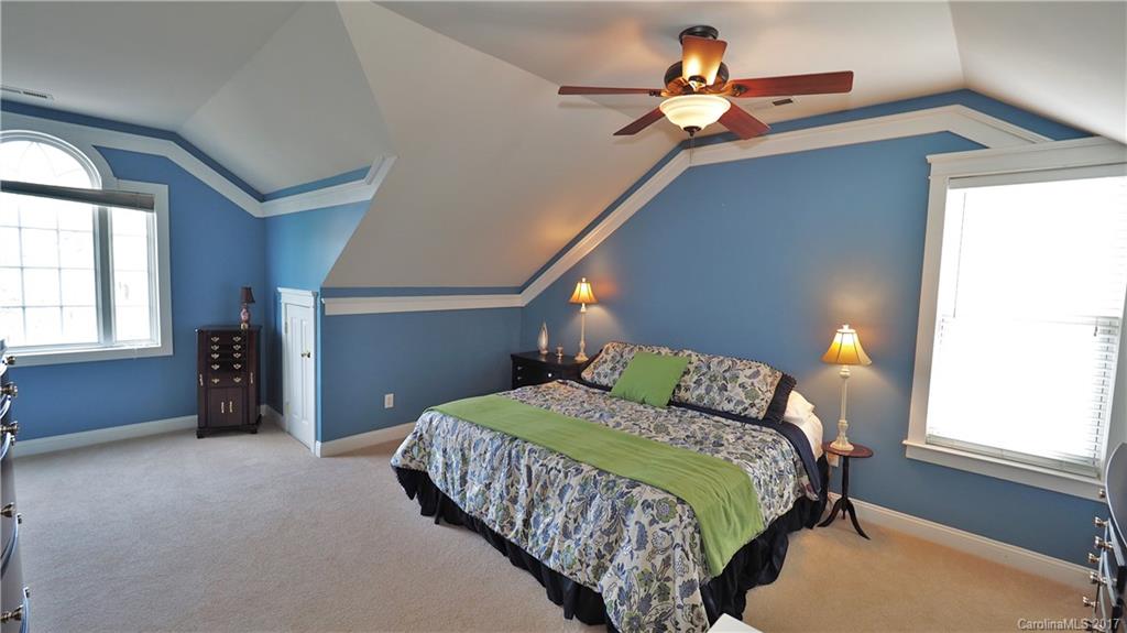 8106 Strandhill Road, Unit 12 Huntersville, NC 28078 - Photo 13 of 24 a bedroom with a bed and a chandelier
