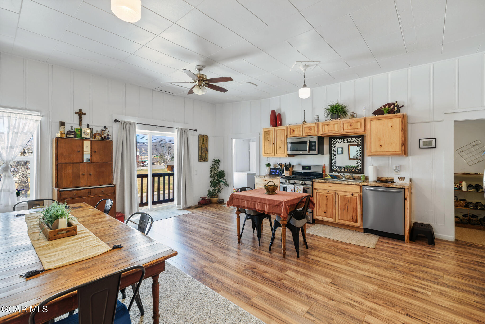 104 3rd Street Kremmling, CO 80459 - Photo 42 of 71 a dining room with wooden floor a chandelier a wooden table and chairs