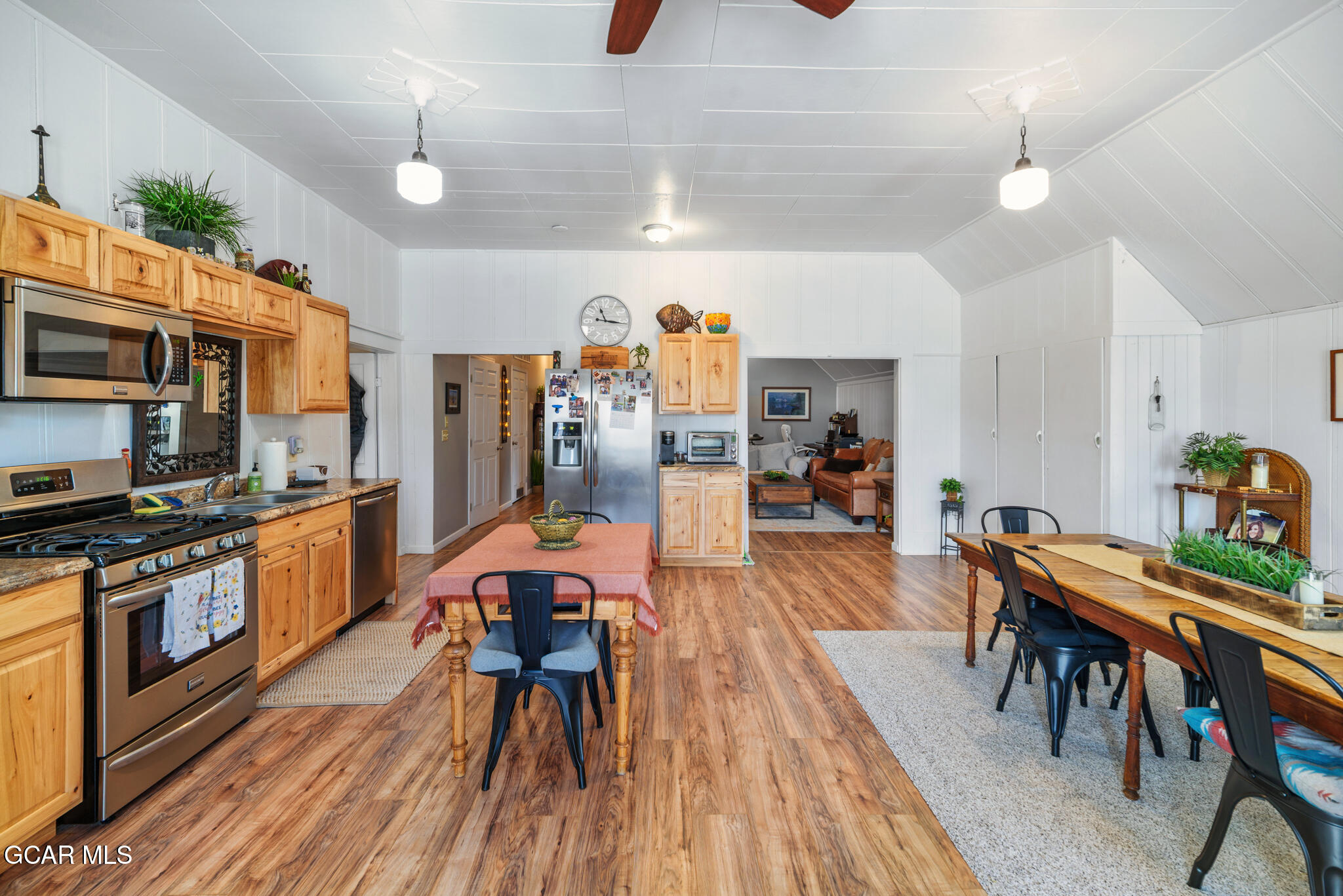 104 3rd Street Kremmling, CO 80459 - Photo 43 of 71 a kitchen with stainless steel appliances a dining table chairs stove refrigerator and cabinets