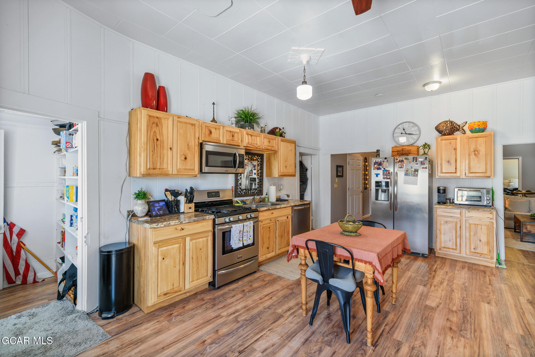 104 3rd Street Kremmling, CO 80459 - Photo 44 of 71 a open kitchen with stainless steel appliances granite countertop a refrigerator a stove top oven a sink dishwasher and white cabinets with wooden floor