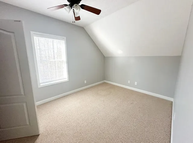 an empty room with a window and a ceiling fan