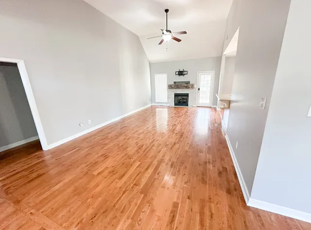 a view of empty room with wooden floor