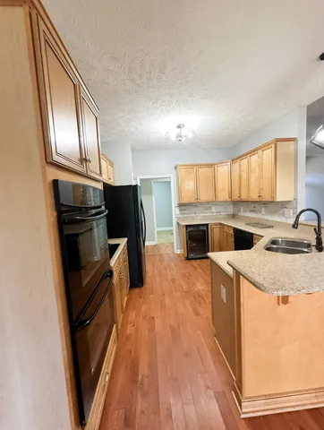 a kitchen with granite countertop a refrigerator stove and sink