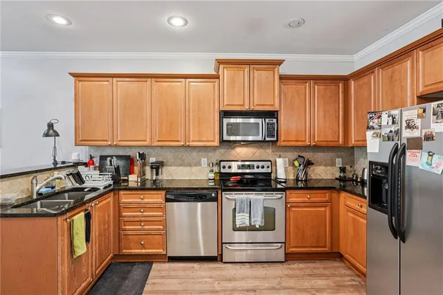 a kitchen with granite countertop a stove top oven sink and cabinets