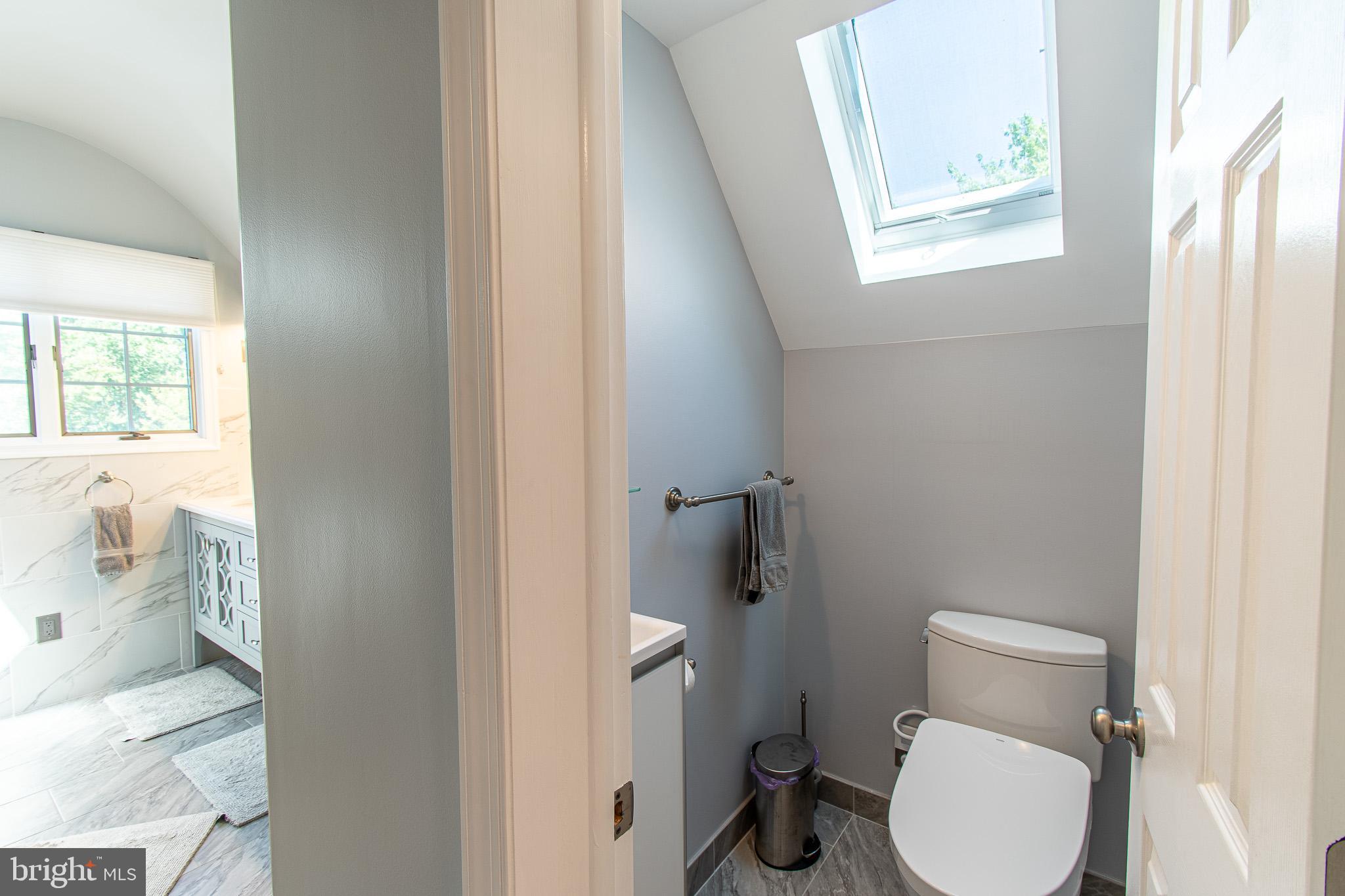 102 Jacks Point Road Oxford, MD 21654 - Photo 52 of 83 a white toilet sitting next to a bathroom sink and a window