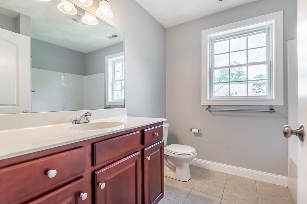 12 Bell Road Tewksbury, MA 01876 - Photo 16 of 26 a bathroom with a granite countertop sink a toilet and a mirror