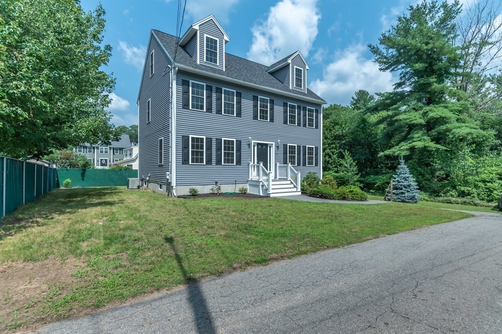 12 Bell Road Tewksbury, MA 01876 - Photo 2 of 26 a front view of a house with a yard and trees