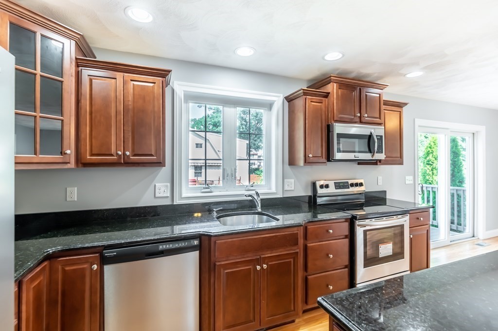 12 Bell Road Tewksbury, MA 01876 - Photo 6 of 26 a kitchen with stainless steel appliances granite countertop a sink stove and microwave