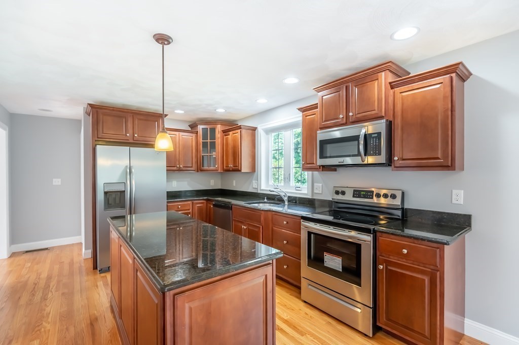 12 Bell Road Tewksbury, MA 01876 - Photo 7 of 26 a kitchen with stainless steel appliances granite countertop a sink a microwave a stove and refrigerator