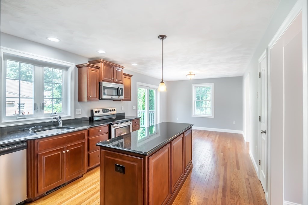 12 Bell Road Tewksbury, MA 01876 - Photo 8 of 26 a kitchen with stainless steel appliances granite countertop a sink stove and wooden floor