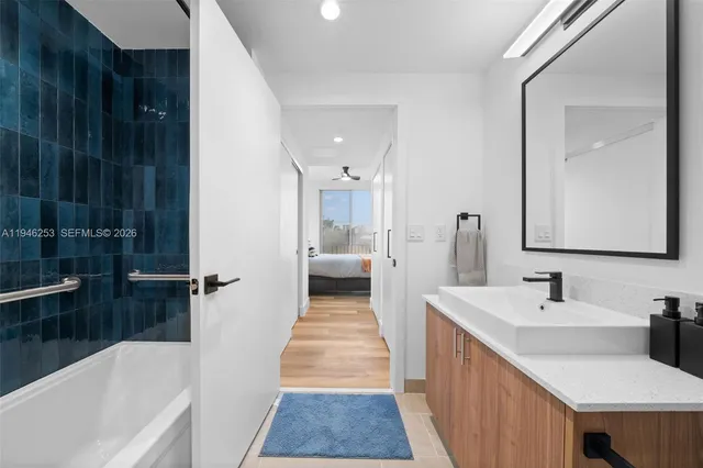 a en suite bathroom with a tub sink and mirror