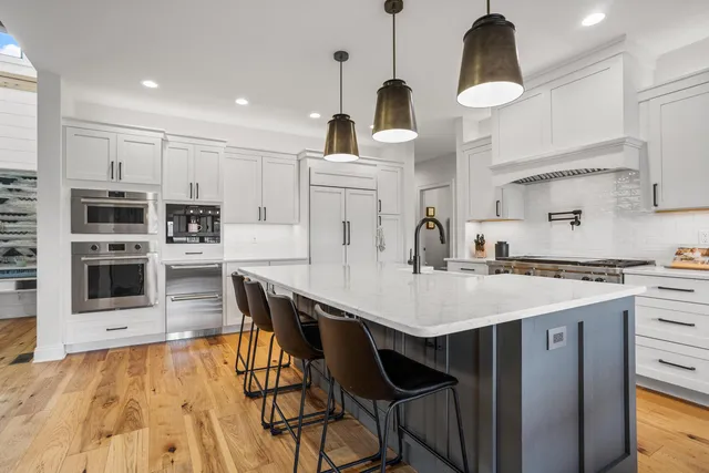 a kitchen with stainless steel appliances a stove and wooden floor