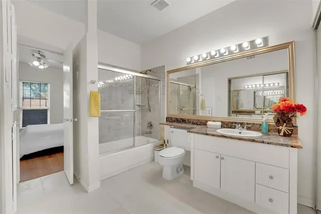 a bathroom with a double vanity sink mirror and toilet