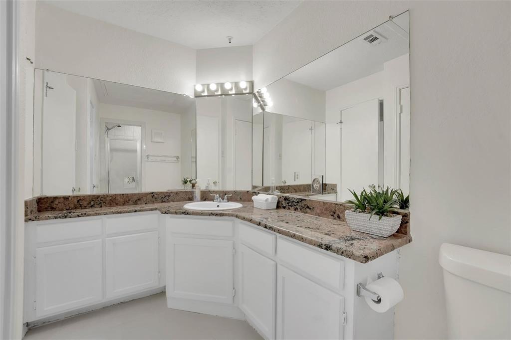 1700 Amelia Court, Unit 312 Plano, TX 75075 - Photo 20 of 30 a bathroom with a granite countertop sink and a mirror