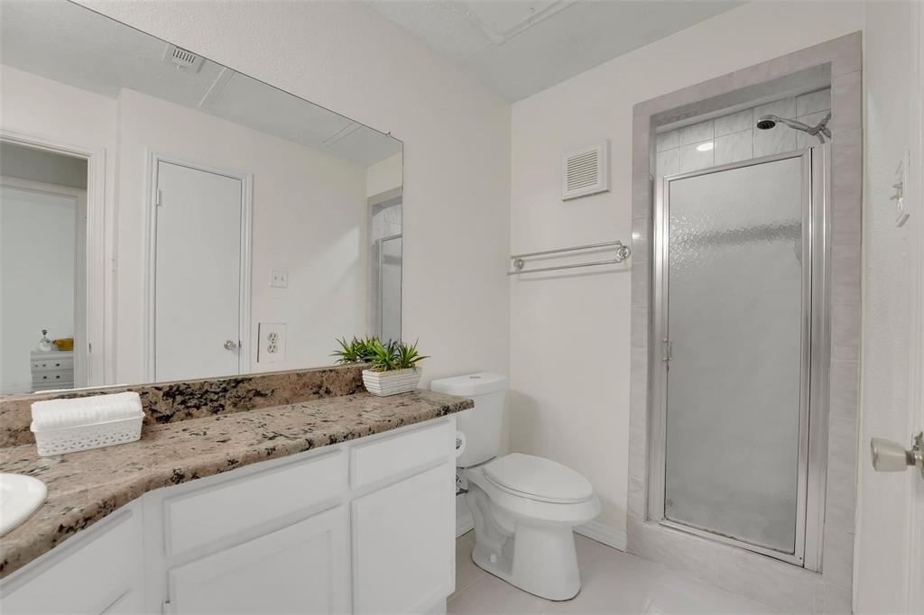 1700 Amelia Court, Unit 312 Plano, TX 75075 - Photo 21 of 30 a bathroom with a granite countertop sink and a mirror