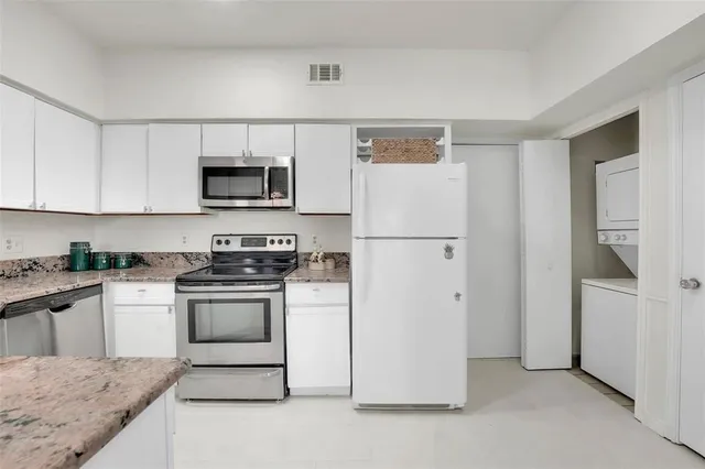 a kitchen with stainless steel appliances granite countertop a refrigerator stove a sink and a microwave