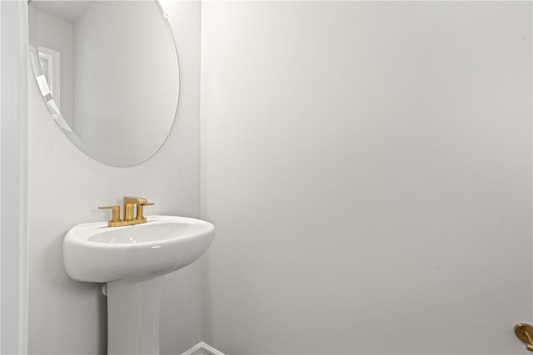 631 Sweetspire Trail, Unit 148 Seneca, SC 29678 - Photo 21 of 36 A sleek pedestal sink with brass fixtures and a minimalist oval mirror defines this powder room.