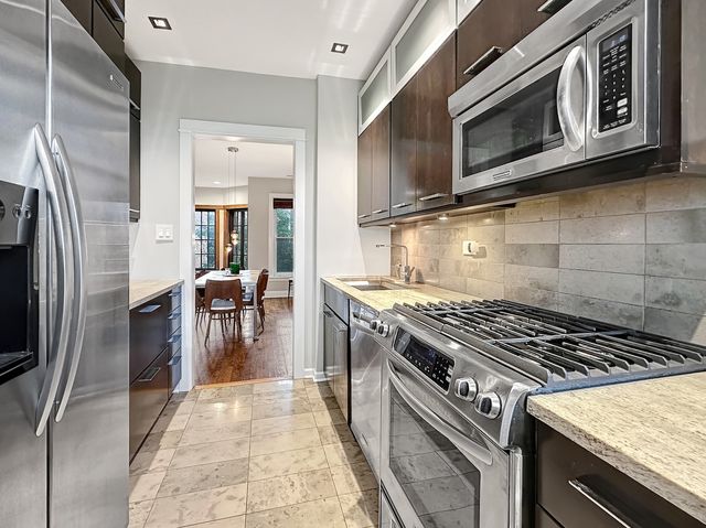 a kitchen with granite countertop a stove top oven microwave and cabinets