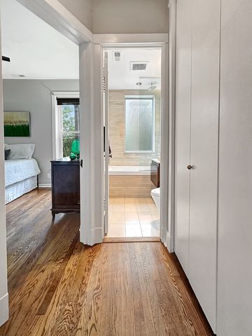 a view of a hallway with wooden floor and cabinet