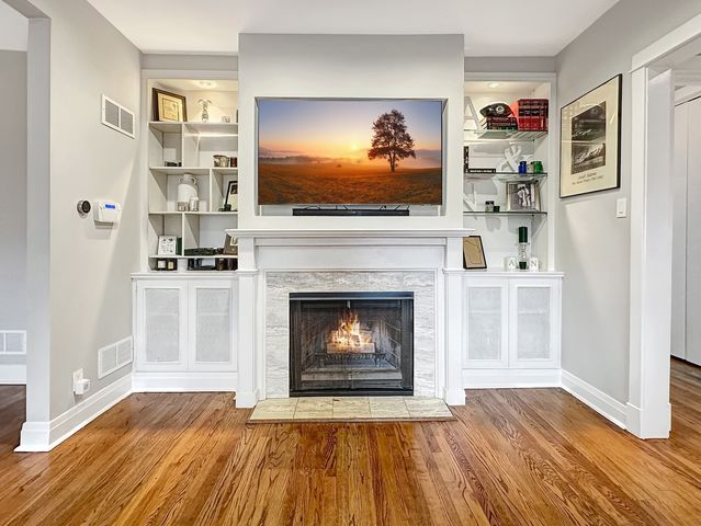 a living room with stainless steel appliances furniture a fireplace and flat screen tv