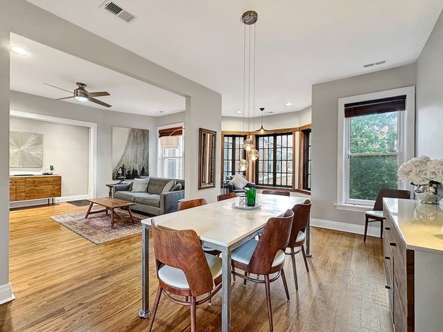 a view of a dining room and livingroom with furniture wooden floor a chandelier