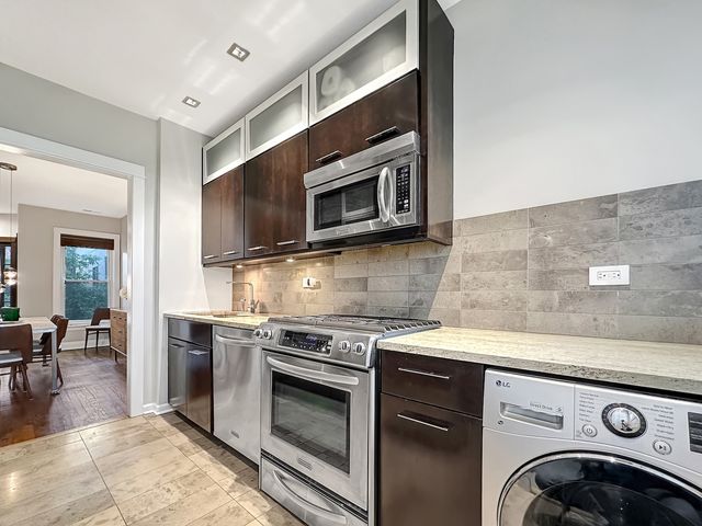 a kitchen with stainless steel appliances granite countertop a stove microwave and sink