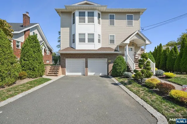 a front view of a house with a yard and potted plants