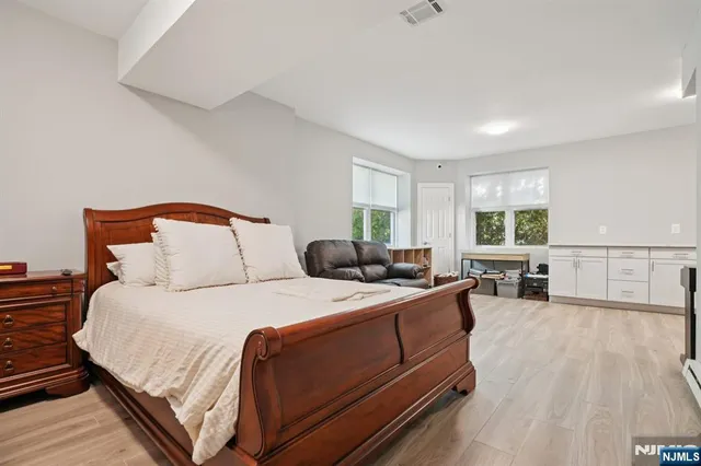 a bedroom with a bed and wooden floor