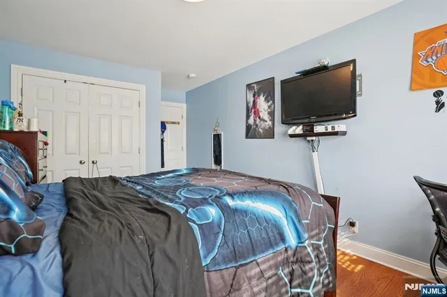 a bedroom with a bed and a flat screen tv
