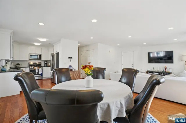 a living room with furniture a flat screen tv and kitchen view