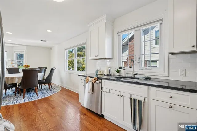 a kitchen with stainless steel appliances granite countertop a stove a sink a dining table and chairs