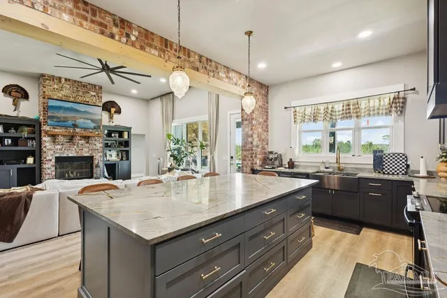 a kitchen with a stove a sink dishwasher and a dining table with wooden floor