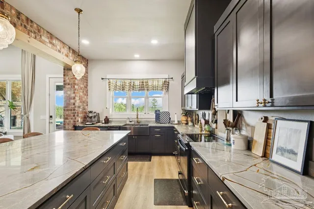a kitchen with granite countertop a sink counter top space cabinets and stainless steel appliances