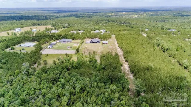a view of a big house with a big yard and large trees