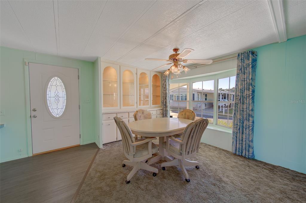 12501 Ulmerton Road, Unit 128 Largo, FL 33774 - Photo 17 of 71 a dining room with furniture large window and wooden floor