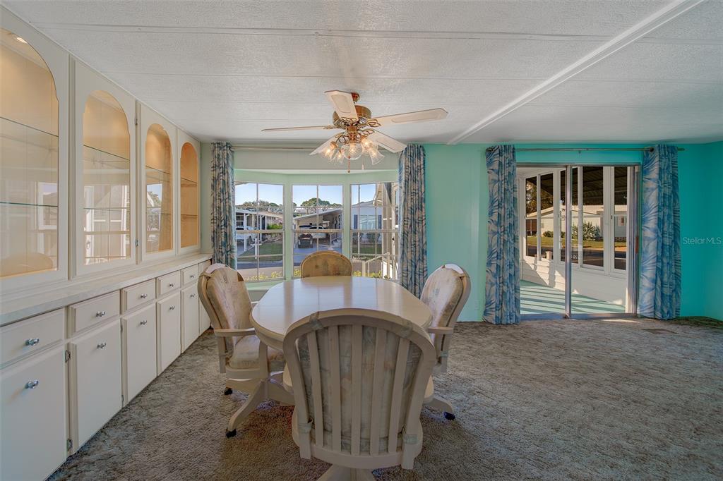 12501 Ulmerton Road, Unit 128 Largo, FL 33774 - Photo 18 of 71 a view of a dining room with furniture a chandelier and large windows