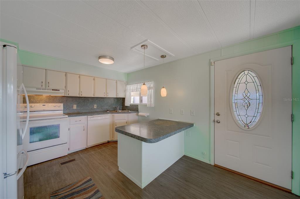 12501 Ulmerton Road, Unit 128 Largo, FL 33774 - Photo 4 of 71 a kitchen with cabinets and wooden floor