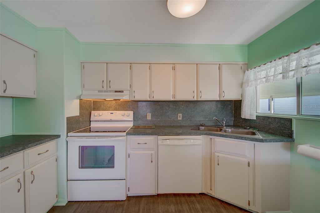 12501 Ulmerton Road, Unit 128 Largo, FL 33774 - Photo 6 of 71 a kitchen with granite countertop white cabinets and white appliances