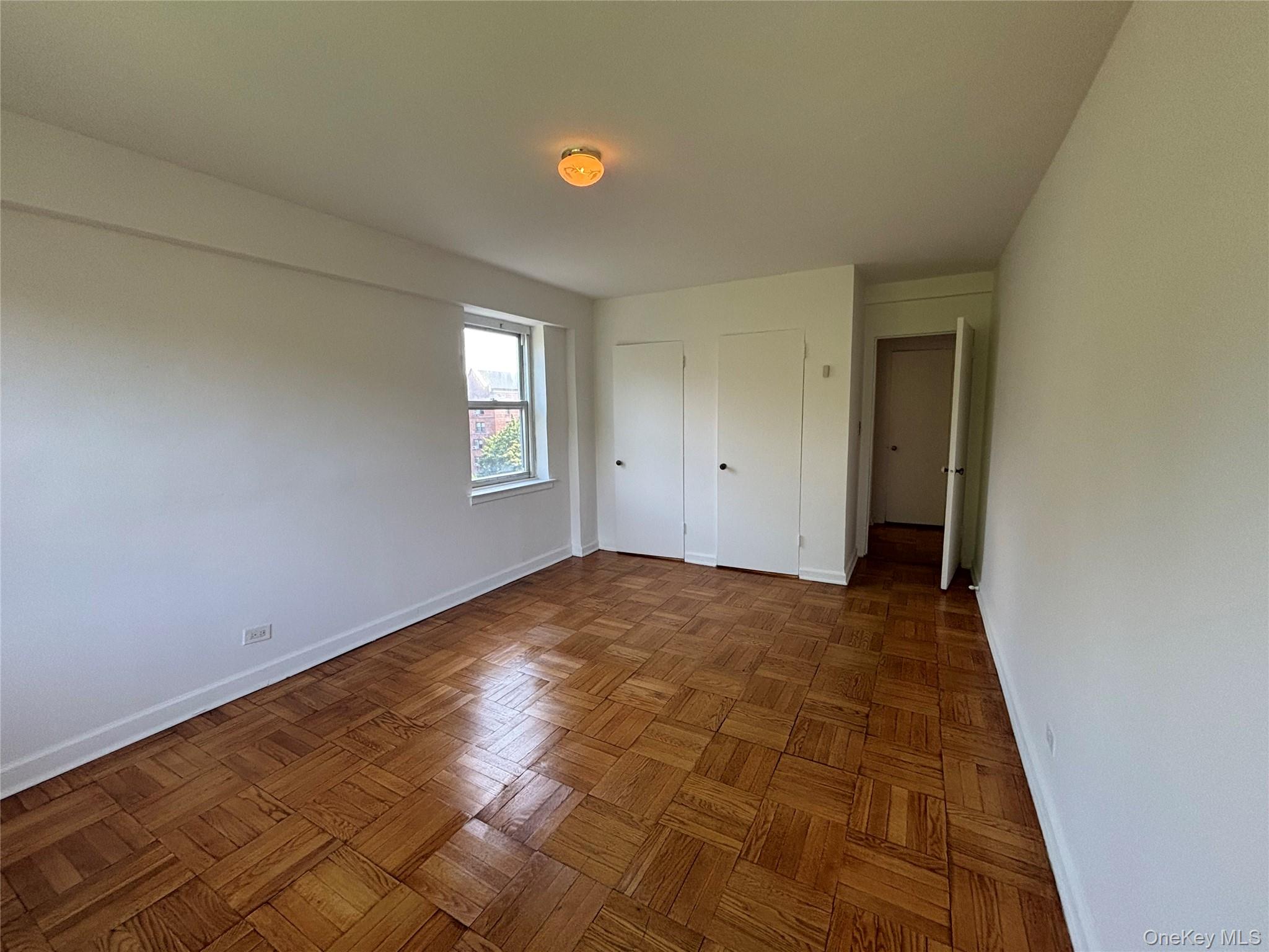 235 Garth Road, Unit A6F Scarsdale, NY 10583 - Photo 9 of 9 Alternate view of Bedroom Parquet wood flooring, a double window, and built-in closet storage