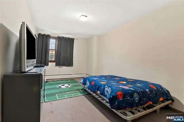 a bedroom with a bed window and dresser