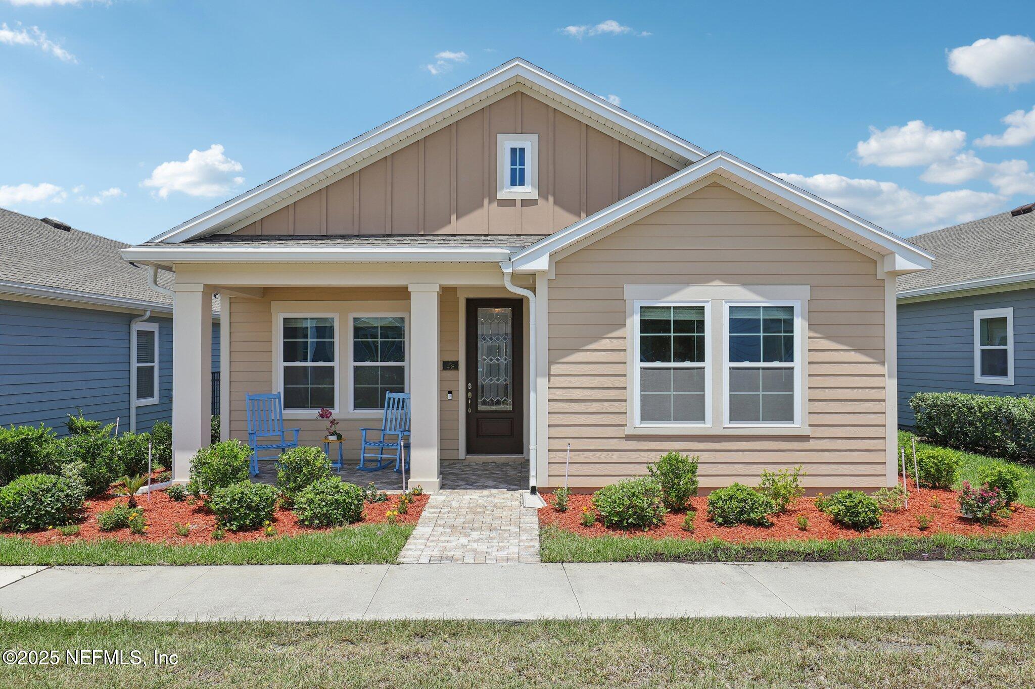 a front view of a house with a yard and flowers