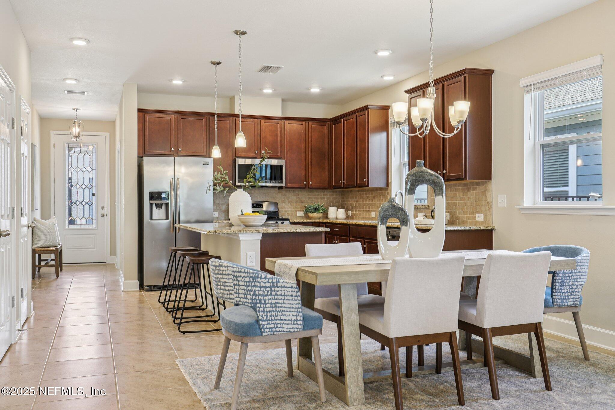 48 Gilchrist Way St. Augustine, FL 32092 - Photo 7 of 50 a kitchen with a dining table chairs refrigerator and cabinets