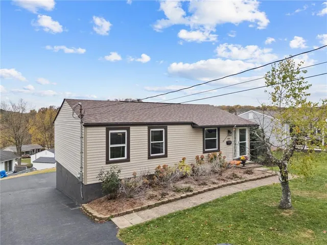 a view of a house with table and chairs next to a yard with wooden fence